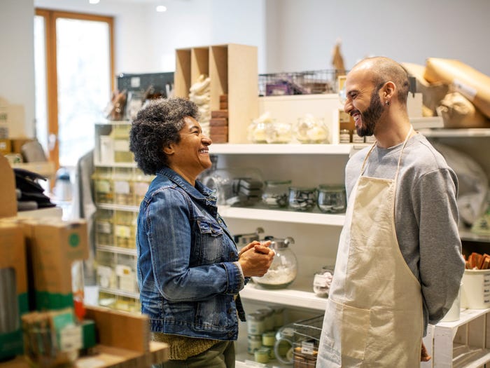 Business owner helping customer in shop